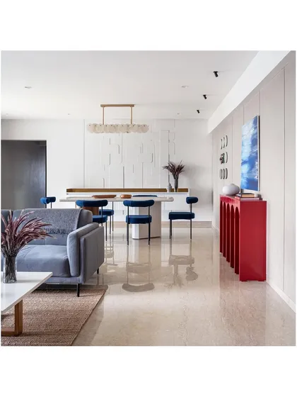 A full view of the living and dining space from our 'Vishu Home' project, which we submitted for the Design Pataki debut. The open-plan layout is unified by a consistent color palette and pops of red and blue.