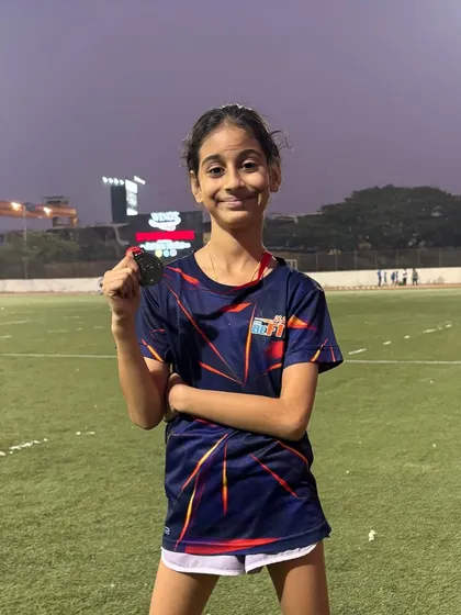 A happy Nataniya holding her bronze medal after a great performance in the 50m sprint. Her hard work in training is clearly showing.