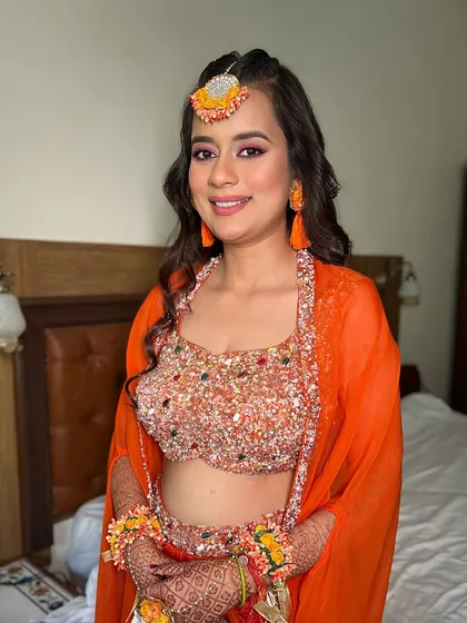 An orange and golden glow for your Haldi ceremony. This look radiates joy and tradition, with a pop of color on the eyes and a bright, happy smile.