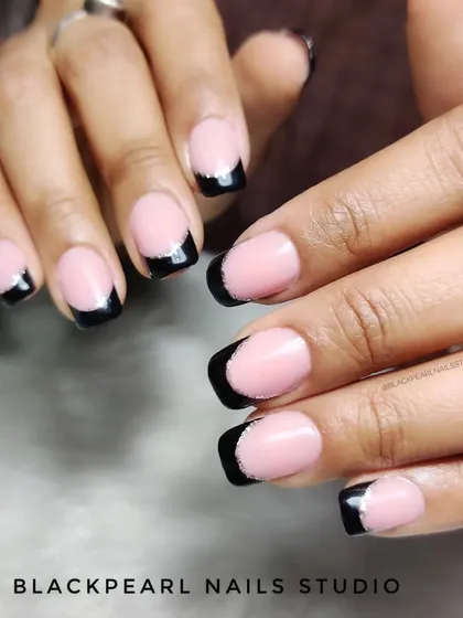 A bold and edgy take on the French manicure, featuring black tips with a subtle silver chrome line. This design is perfect for clients who want a classic style with a modern, dramatic twist.