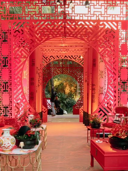 An enchanting Chinese-themed decor setup, with intricate red lattice archways creating a stunning and culturally rich entrance for a reception.