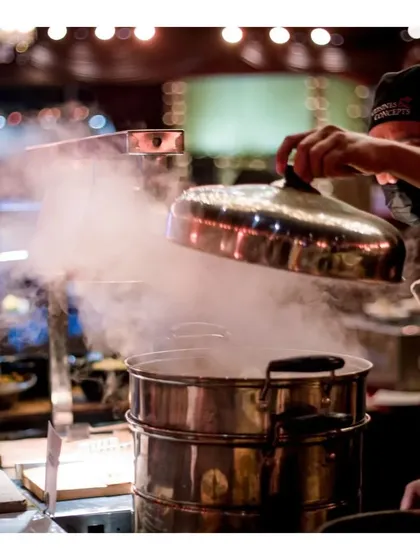 The steam rises as our chef lifts the lid off a large steamer, ready to serve hot and fresh dim sum.
