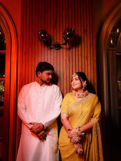 Golden vibes and haldi dreams. A beautiful couple portrait from a haldi ceremony, with the bride glowing in a yellow saree and floral jewelry.