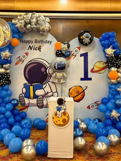 A centered shot of the astronaut-themed photo booth, showing the character cutouts and planet details.