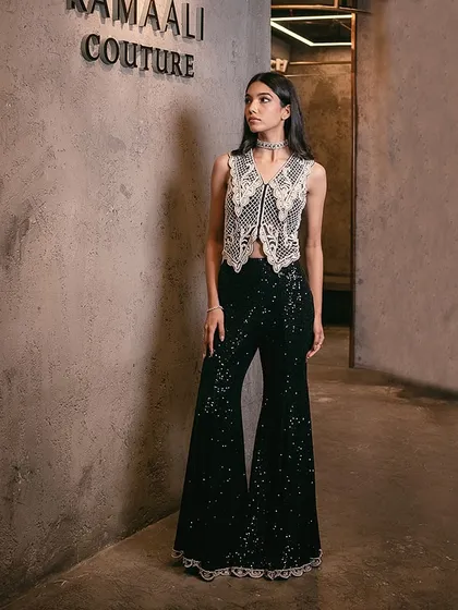 A festive look featuring a charcoal black waistcoat intricately embellished with pearls, paired with sequin-adorned flared pants.