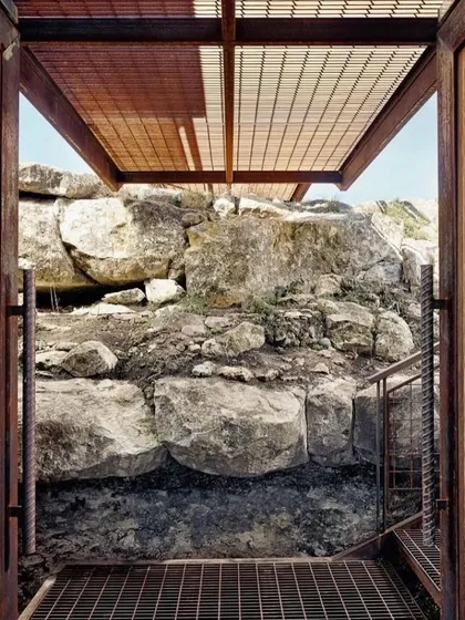 The entrance to one of our hillside homes, showcasing the use of industrial materials like steel mesh for stairs and ceilings. This creates a modern, durable aesthetic that complements the natural rock formations.