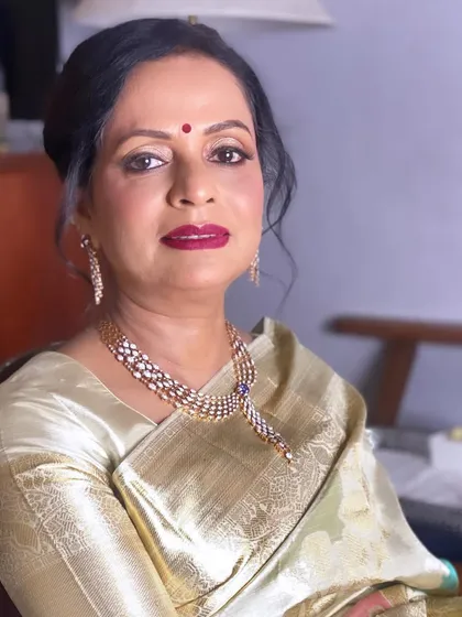A portrait of the glamorous mother of the groom. Her look features a bold lip and defined eyes, perfect for a wedding reception and making sure the groom's side is represented with style.