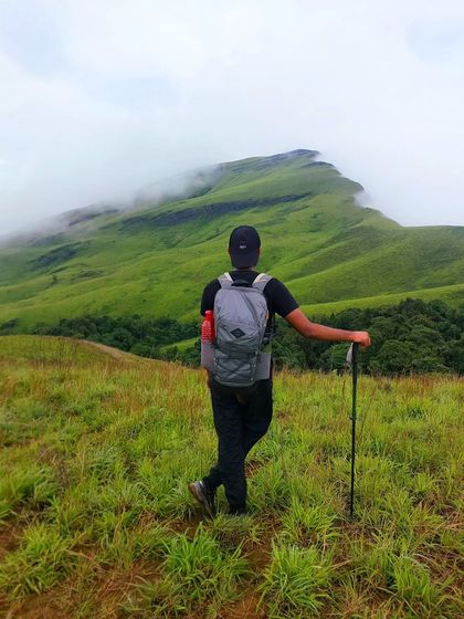 Another angle of a trekker lost in the beauty of the misty green mountains. These are the moments of peace we chase.
