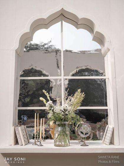 A beautiful detail from the ivory-toned lounge decor. The window shelf was styled with books, candles, and a simple floral arrangement, making the space feel elegant and lived-in.