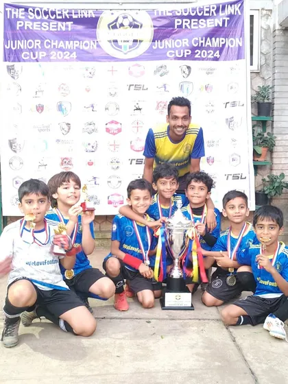 The U9s with their coach and their well-earned trophy after a competitive tournament.