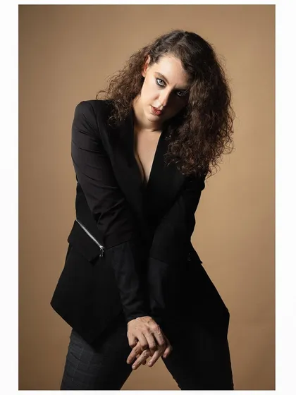 A more dynamic pose from the same series, with the model leaning forward to create a sense of intensity.