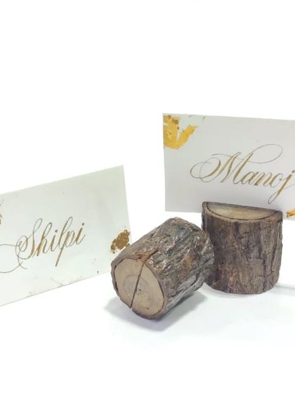 Embrace a natural, rustic aesthetic with these wooden log place card holders. Paired with elegantly calligraphed name cards, they are perfect for woodland-themed weddings, outdoor events, or simply bringing a bit of nature indoors.