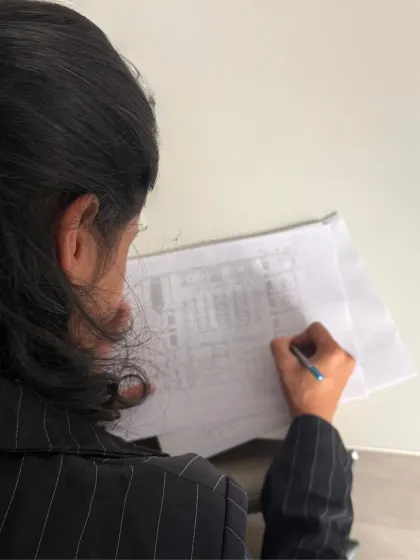 The process often involves layering ideas. Here, an architect sketches over a printed plan, exploring alternatives and refining the design in an iterative loop between digital and analog methods.