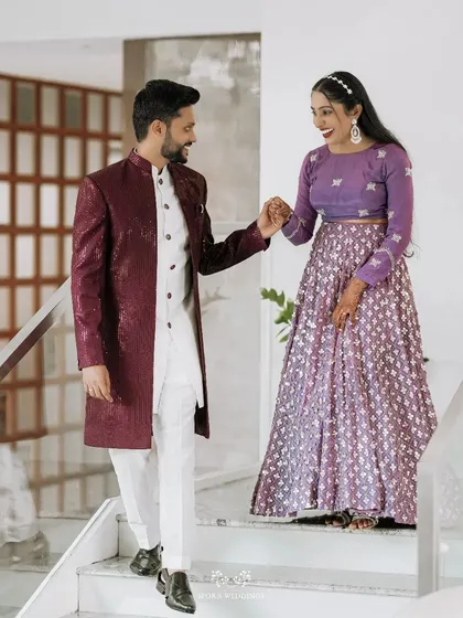 The couple walking down the stairs together, their coordinated outfits in purple and maroon looking incredibly stylish.