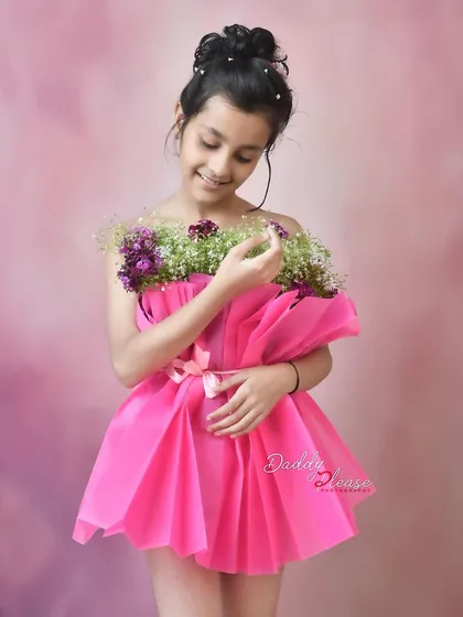 A sweet and gentle portrait of the girl looking down at the flowers that make up her dress. It's a quiet, beautiful moment captured during the session.