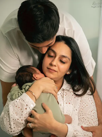 A new family sharing a quiet, loving embrace. The focus is on their connection and the peaceful joy of having a new baby.