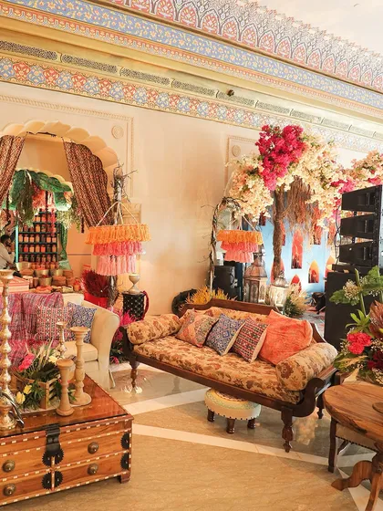 A lounge area filled with luxurious printed sofas, colorful cushions, and lush floral arrangements. I create comfortable and stylish spaces for guests to relax and mingle.