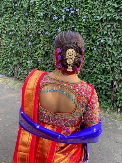 Another angle of this intricate bridal updo. The combination of the braid, flowers, and jewelry creates a truly regal look.