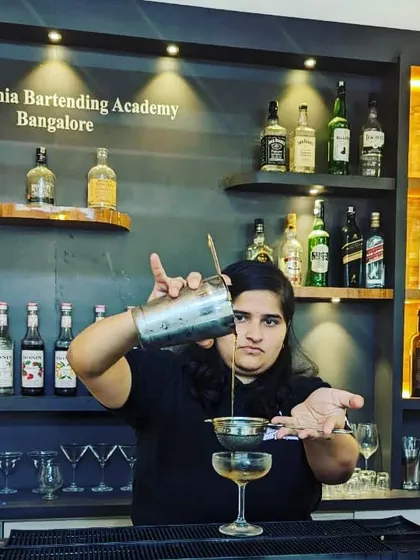 Precision is key in professional bartending. Here, a student at our Bangalore academy practices the double-straining technique to ensure a perfectly smooth cocktail, free of ice chips and pulp.