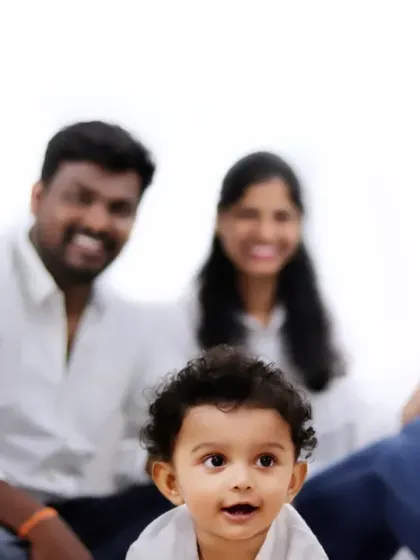 A creative family portrait with the focus on the baby's curious expression, while the parents' joyful smiles create a beautiful, soft background.