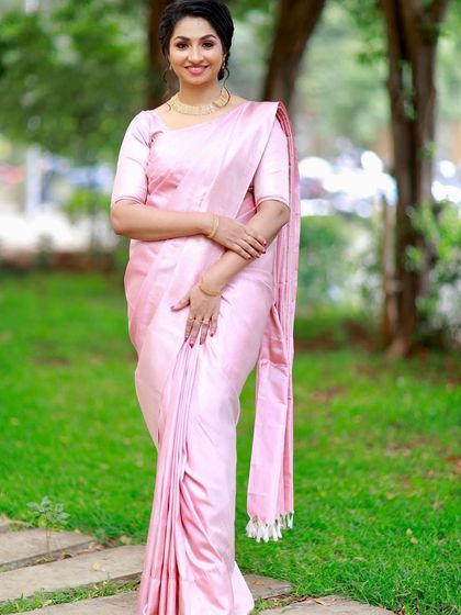A simple, elegant drape in a soft pink satin saree. This minimalist style is perfect for daytime events or for those who prefer an understated look.