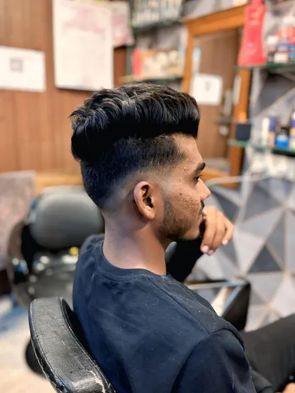 This high fade haircut is styled with the top pushed up and forward for maximum volume. It's a strong and confident look.