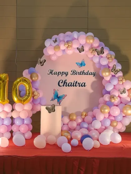 A delicate butterfly theme for a 10th birthday, using a pastel balloon arch and a custom circular backdrop.