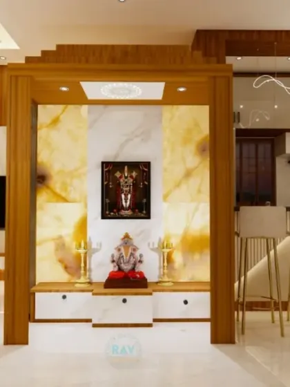 A render of a pooja unit with a backlit onyx-style panel, creating a divine glow. The unit is seamlessly integrated between the living area and the kitchen.