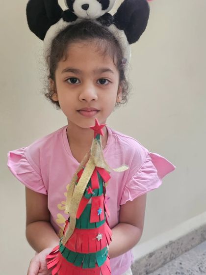 Another one of our students with her handcrafted paper Christmas tree, complete with a star on top.