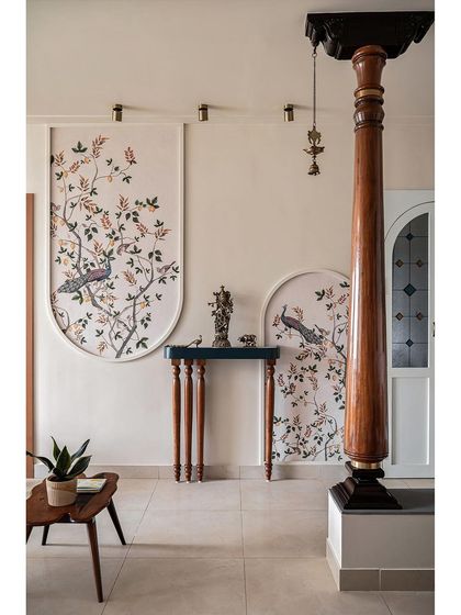 Another view of the accent wall, showing how the traditional peacock wallpaper is framed like artwork. The dark wood pillar from the dining area adds another layer of classic architectural detail.