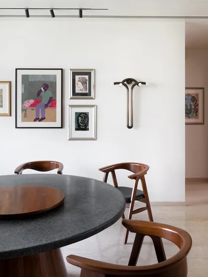 A full view of the round terrazzo dining table and curved teak chairs. I designed this set to encourage conversation, as a round table allows everyone to face each other.