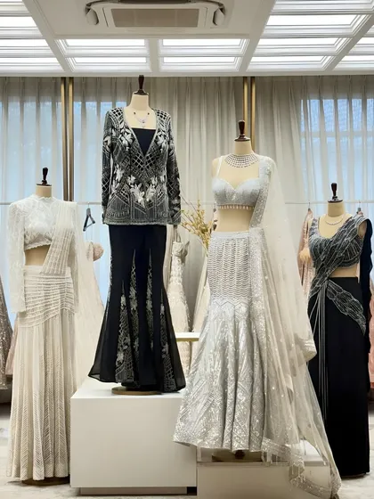 A glimpse of my new collection on display. This shot features a variety of modern lehengas and gowns in black, white, and silver, showcasing different silhouettes and styles.