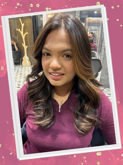 A happy client showing off her fresh balayage and blowout. The soft highlights frame her face beautifully, adding brightness and dimension to her overall look.