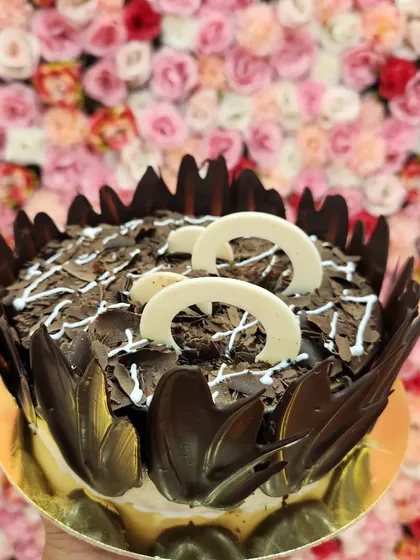 This is my Chocochip Delight cake, loaded with lots of chocolate and love. It's covered in rich chocolate shavings and decorated with white chocolate curls, offering a wonderful mix of textures and chocolatey goodness.