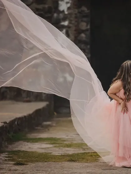 The soft peach color of this net trail gown gives it a romantic, sunset feel. The lightweight fabric is easy to work with and creates beautiful, airy shapes.