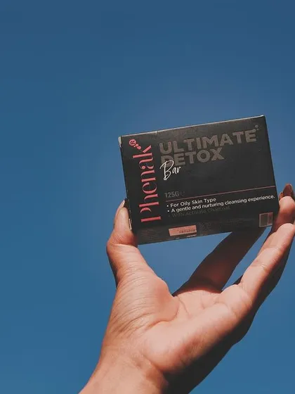Holding up my Ultimate Detox Bar against the clear blue sky. This soap is formulated for oily skin types to provide a gentle yet deep cleansing experience, helping you achieve a balanced and clear complexion.
