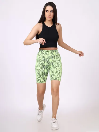 A model walks towards the camera in a black crop top and snakeskin-print shorts. The full-body shot clearly shows the fit and design of the outfit, ideal for an online store.