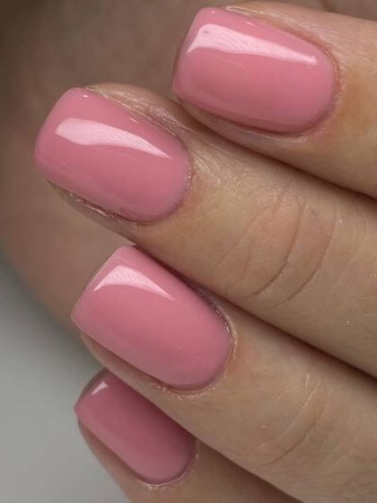 A bright, bubblegum pink manicure on short, square nails. This fun and vibrant color is perfect for adding a pop of personality.