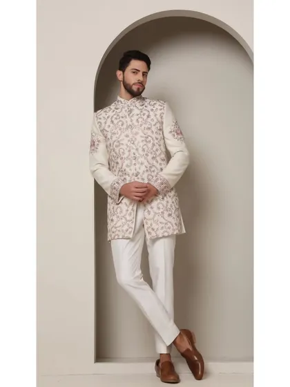 The Ivory Rose bandhgala ensemble. This piece features intricate jaal work and charming boota designs, crafted with fine blush peach thread embroidery and rose gold accents.