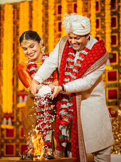 A joyful moment during the wedding ceremony as the couple participates in the fire ritual together.