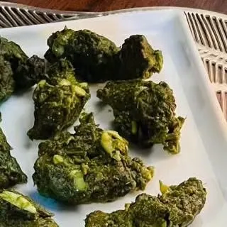 A vegetarian starter, likely a palak (spinach) based dish, showcasing a healthy and flavorful option for guests.