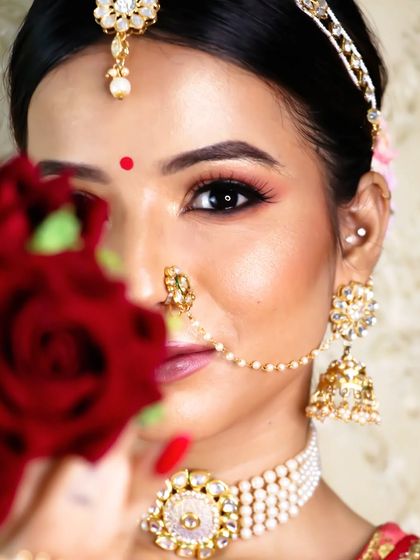 Beauty and grace follow her trace. A creative shot that highlights the bride's stunning eye makeup and traditional jewelry.