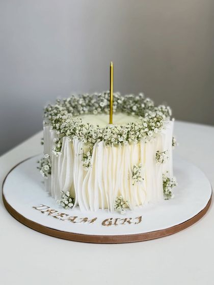 Soft, timeless, and quietly elegant. This minimalist cake is all about delicate details, with flowing textures, fresh baby's breath, and a simple charm that steals the spotlight.