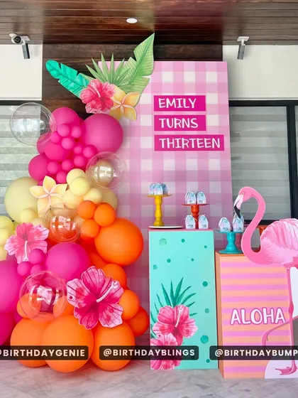 A tropical "Aloha" theme for a 13th birthday. The bright pink and orange balloons, flamingo cutout, and hibiscus flower details create a fun and festive luau vibe.