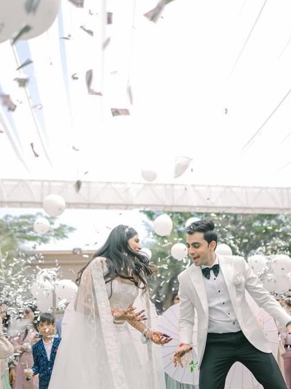A shower of silver confetti and balloons for a festive and fun couple's entry.
