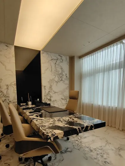 The executive meeting room at the RS head office in Chennai. The space is defined by a statement meeting table made from a single piece of heavily veined marble, complemented by floor-to-ceiling marble walls and soft, natural light to create an atmosphere of quiet authority.