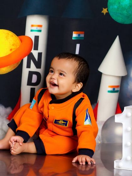 Looking up at the cosmos in wonder. This little astronaut is celebrating his first year with a journey through our space-themed studio set.