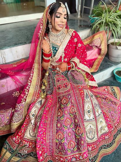 Another angle of the vibrant bridal look, with the bride looking down to showcase the detailed eye makeup.