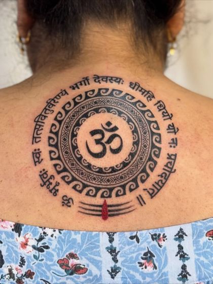A close-up, healed shot of the Om and Gayatri Mantra tattoo, showing how the ink has settled.