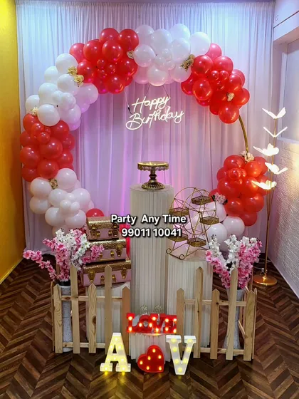 Another view of the red and white circular balloon decoration, showing different prop arrangements with light-up initials "A & V".